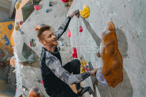 Man climbing wall with grips Stock photo © LightFieldStudios