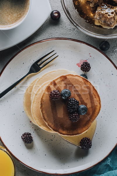 top view of sweet homemade pancakes with berries and honey  Stock photo © LightFieldStudios