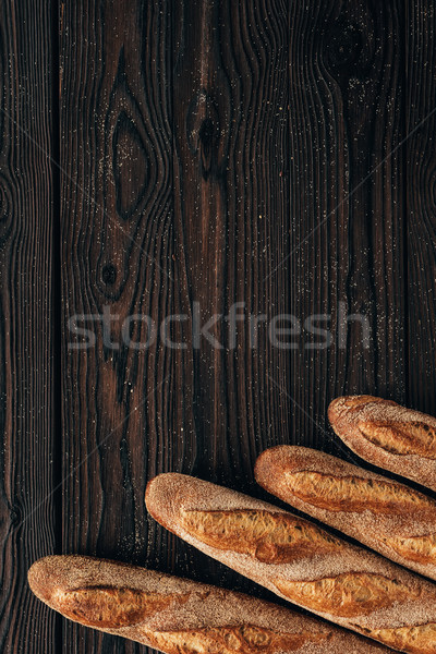 Stock photo: top view of arranged loafs of french baguette on wooden surface