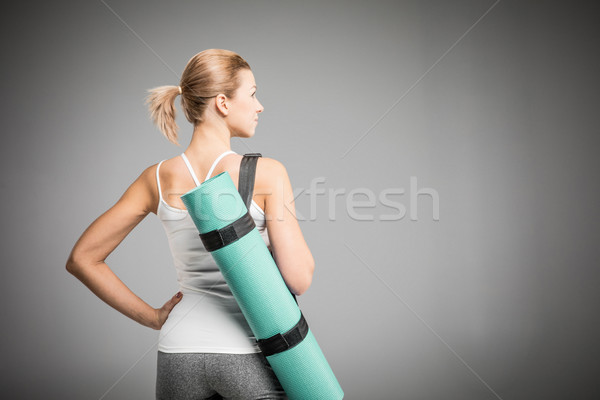Sportswoman holding yoga mat   Stock photo © LightFieldStudios