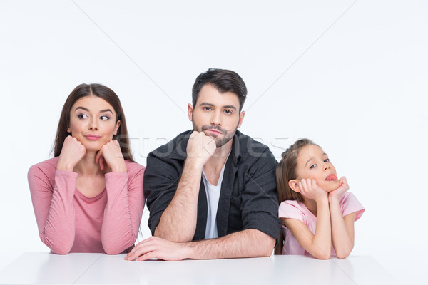 Pensive young family with one child looking at camera on white   Stock photo © LightFieldStudios