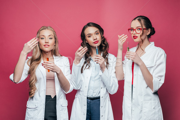 portrait of professional doctors smelling test tubes on pink Stock photo © LightFieldStudios