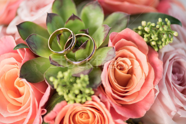 two golden wedding rings on bouquet on roses and succulent, wedding rings and flowers concept Stock photo © LightFieldStudios