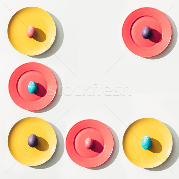 food composition with easter eggs on colorful plates with copy space Stock photo © LightFieldStudios