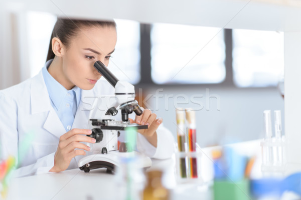 Foto stock: Jovem · concentrado · mulher · cientista · trabalhando · microscópio