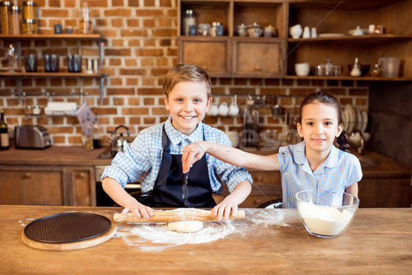 Stock photo: children making pizza dough on wooden tabletop in kitchen 