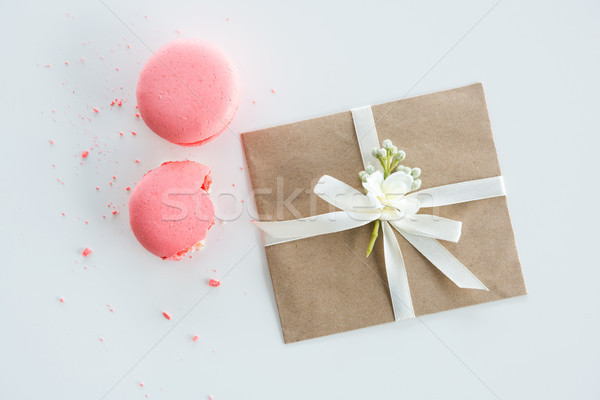 Close-up view of decorative kraft envelope with bow and pink macarons isolated on white, wedding inv Stock photo © LightFieldStudios