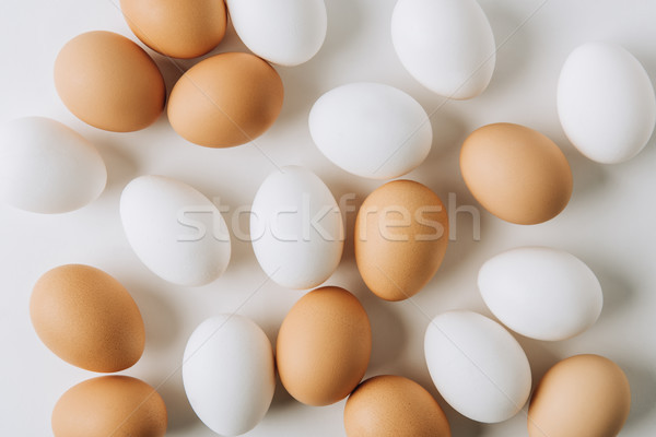 Stock photo: white and brown eggs laying on white background