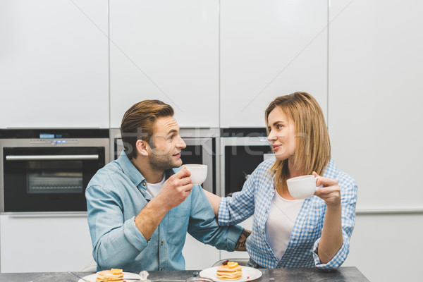 portrait of couple with cups of coffee in kitchen at home Stock photo © LightFieldStudios