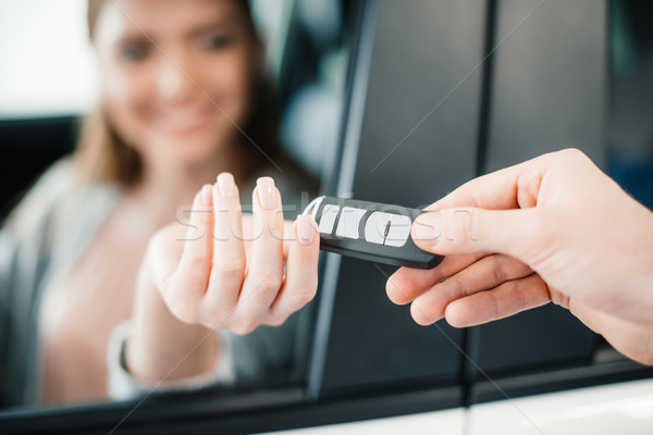 Person giving car key to woman sitting in car in dealership salon    Stock photo © LightFieldStudios