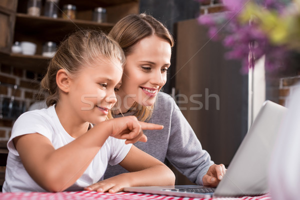 mother and daughter using laptop Stock photo © LightFieldStudios