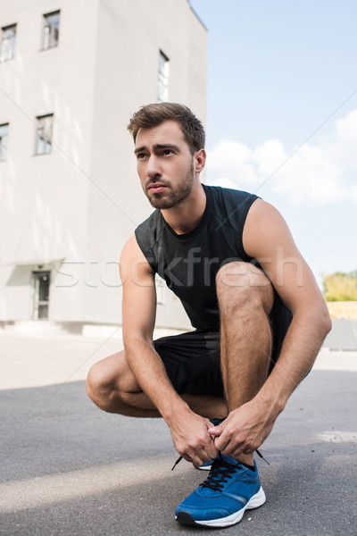 man tying laces on sneakers Stock photo © LightFieldStudios