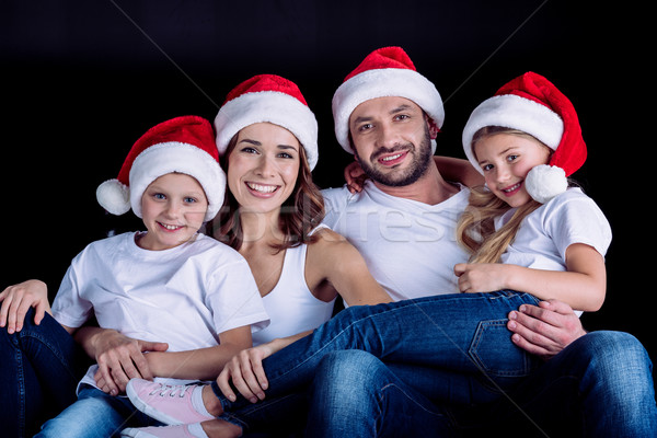 family in Santa hats looking at camera Stock photo © LightFieldStudios