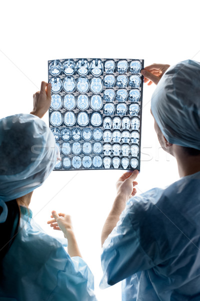 back view of surgeons in medical uniforms examining x-ray image on white Stock photo © LightFieldStudios