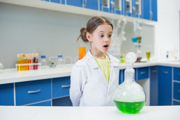 portrait of shocked girl scientist looking at experimental tube in lab Stock photo © LightFieldStudios
