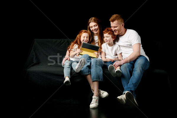 happy family using digital tablet isolated on black Stock photo © LightFieldStudios