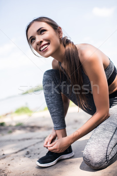 Sportos nő cipőfűző közelkép kilátás mosolyog Stock fotó © LightFieldStudios