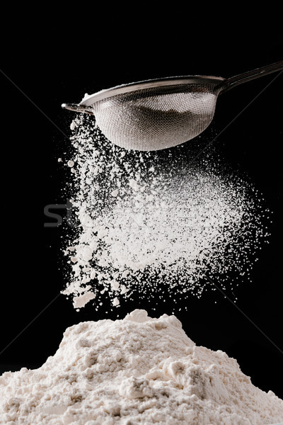 flour falling from sieve on pile isolated on black Stock photo © LightFieldStudios