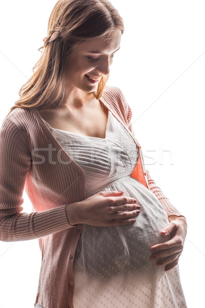 Jovem mulher grávida tocante barriga sorridente branco Foto stock © LightFieldStudios