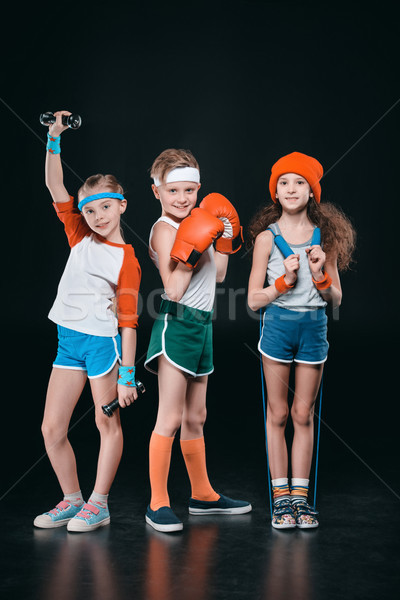 Three active kids in sportswear posing with sport equipment isolated on black  Stock photo © LightFieldStudios