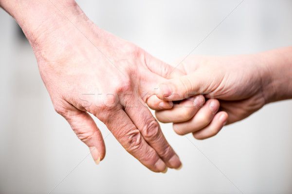 Stock photo: Close-up partial view of grandmother and child holding hands 