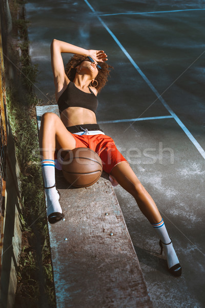 woman in sportswear and heels on bench Stock photo © LightFieldStudios