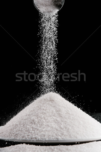 sugar falling from metal scoop on pile on plate isolated on black Stock photo © LightFieldStudios