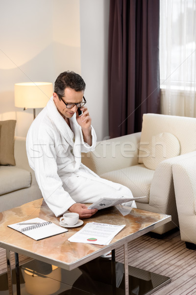 Businessman in bathrobe talking on phone Stock photo © LightFieldStudios