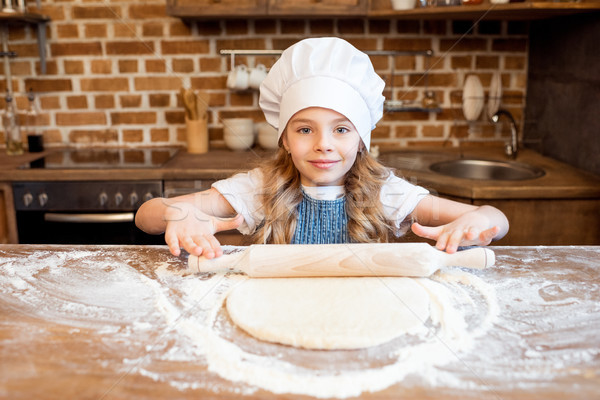 girl in chef hat rolling out raw pizza dough  Stock photo © LightFieldStudios