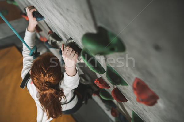 girl climbing wall with grips Stock photo © LightFieldStudios