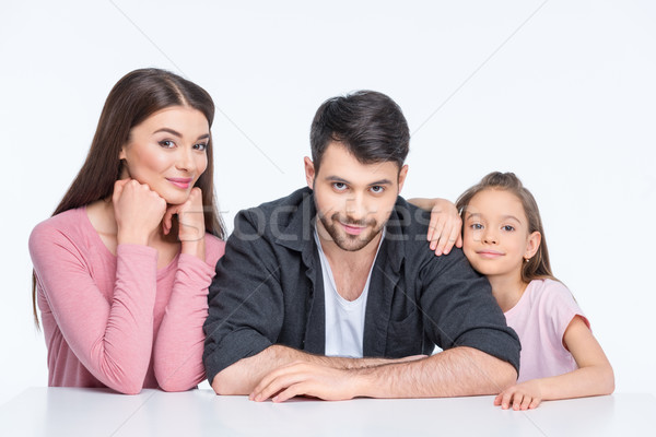 Happy young family with one child looking at camera on white   Stock photo © LightFieldStudios