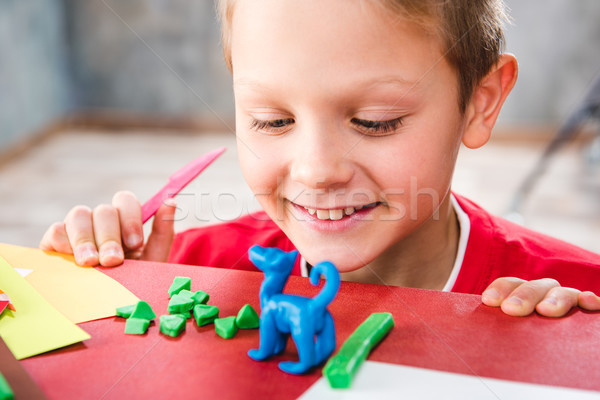 Schoolchild making toy from plasticine Stock photo © LightFieldStudios