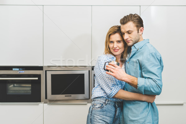 portrait of couple hugging each other in kitchen at home Stock photo © LightFieldStudios