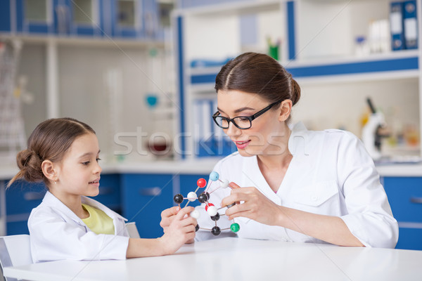 Smiling woman and little girl in lab coats working with molecular model Stock photo © LightFieldStudios