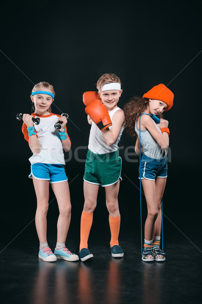 Three active kids in sportswear posing with sport equipment isolated on black  Stock photo © LightFieldStudios