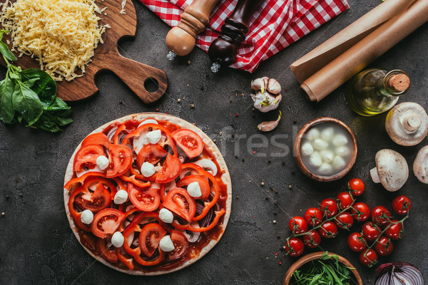 top view of uncooked pizza with ingredients on concrete table Stock photo © LightFieldStudios