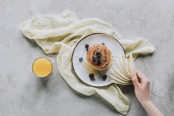 cropped shot of person holding sliced pear above tasty homemade pancakes with berries and honey  Stock photo © LightFieldStudios