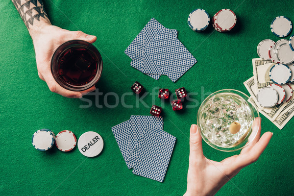 Man and woman with drinks gambling by table with dice and cards Stock photo © LightFieldStudios