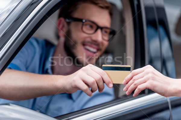 Homme payer carte de crédit mise au point sélective conduite voiture [[stock_photo]] © LightFieldStudios