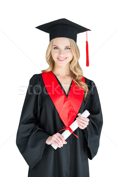 Beautiful young woman in academic cap holding diploma and smiling at camera Stock photo © LightFieldStudios