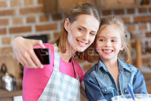 portrait of smiling mother and daughter making selfie while cooking at home Stock photo © LightFieldStudios