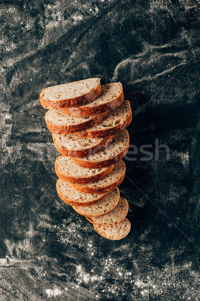 top view of arranged pieces of bread on dark surface with flour Stock photo © LightFieldStudios