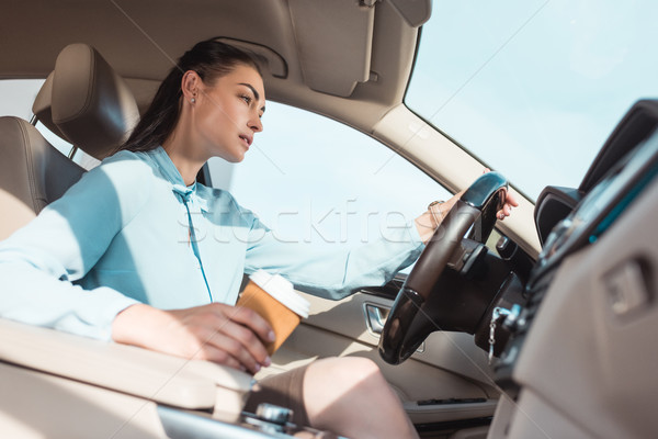 woman driving car with coffee Stock photo © LightFieldStudios