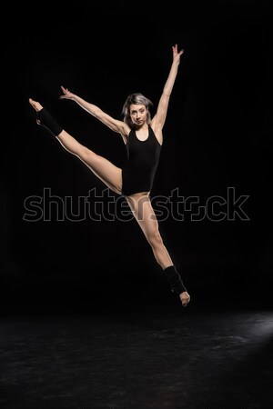 beautiful jumping woman in bodysuit on black Stock photo © LightFieldStudios