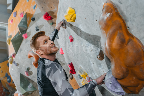 Man climbing wall with grips Stock photo © LightFieldStudios