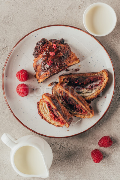flat lay with arranged jug and cup of milk and sweet pastry with raspberries on plate on light table Stock photo © LightFieldStudios