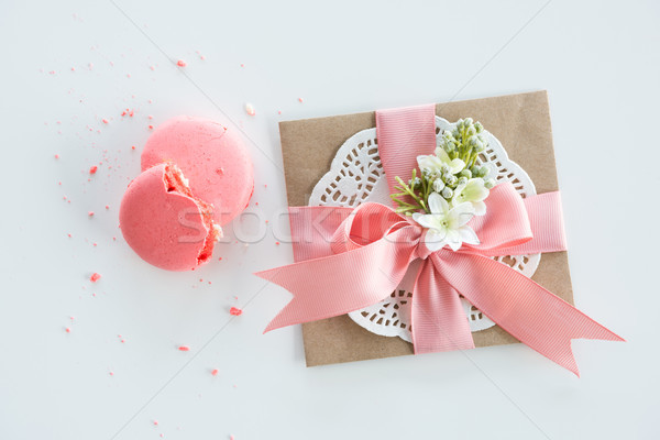 Top view of decorative kraft envelope with bow and pink macarons isolated on white, wedding invitati Stock photo © LightFieldStudios