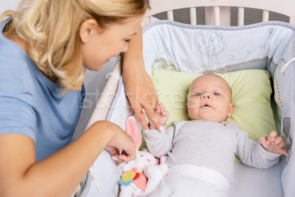 mother looking at baby in crib Stock photo © LightFieldStudios