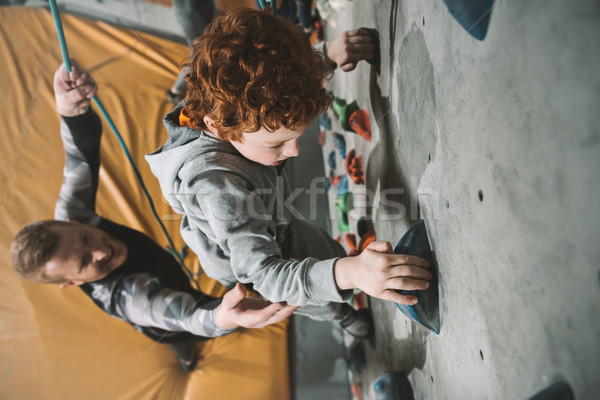 Little boy climbing wall at gym Stock photo © LightFieldStudios