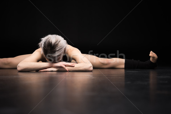 Sporty young woman dancer stretching on black Stock photo © LightFieldStudios